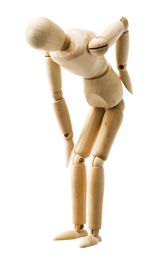A wooden mannequin bent forward with one hand pressed to the small of its back